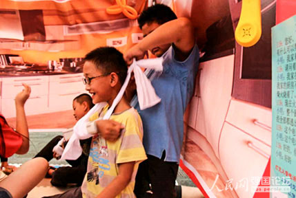 游園會上,小朋友演練模擬包扎。